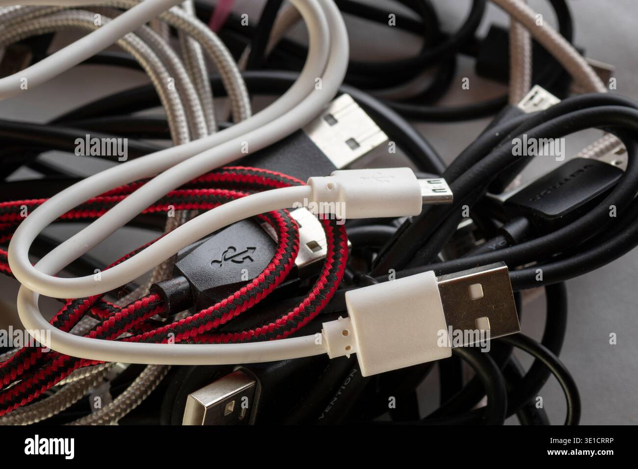 Various USB cables and connectors tangled together showing everyday ...