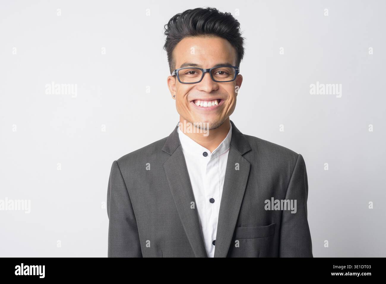 Studio shot of young Asian businessman in suit wearing eyeglasses against white background Stock Photo