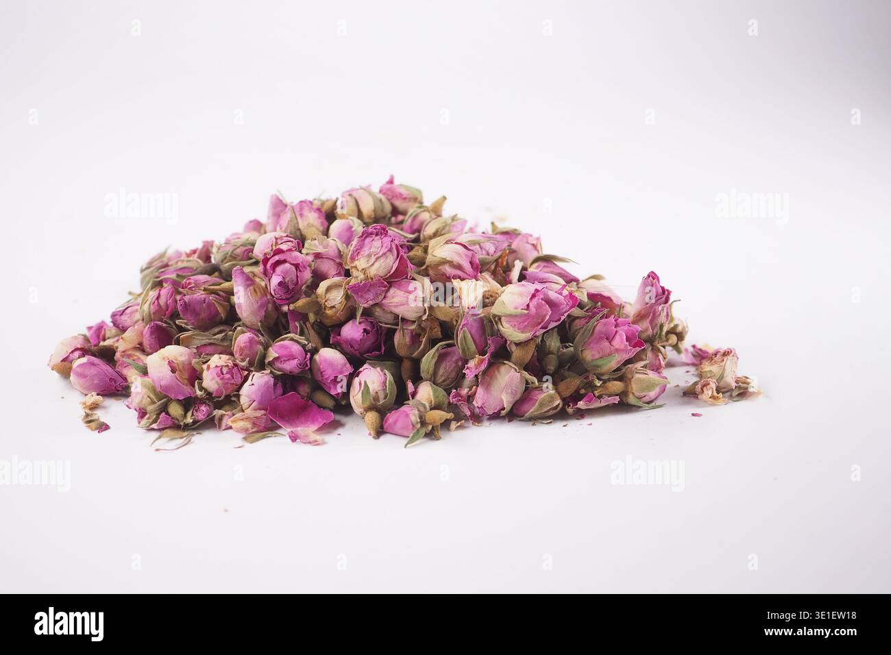 Dried pink rose buds on a white surface Stock Photo