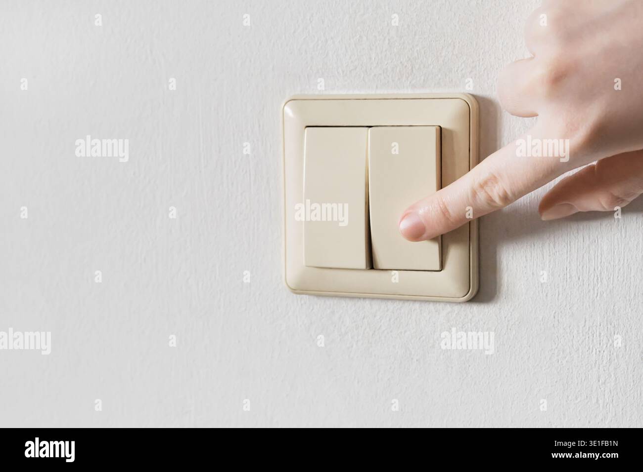 Hand pressing an electrical wall switch controlling energy and power ...