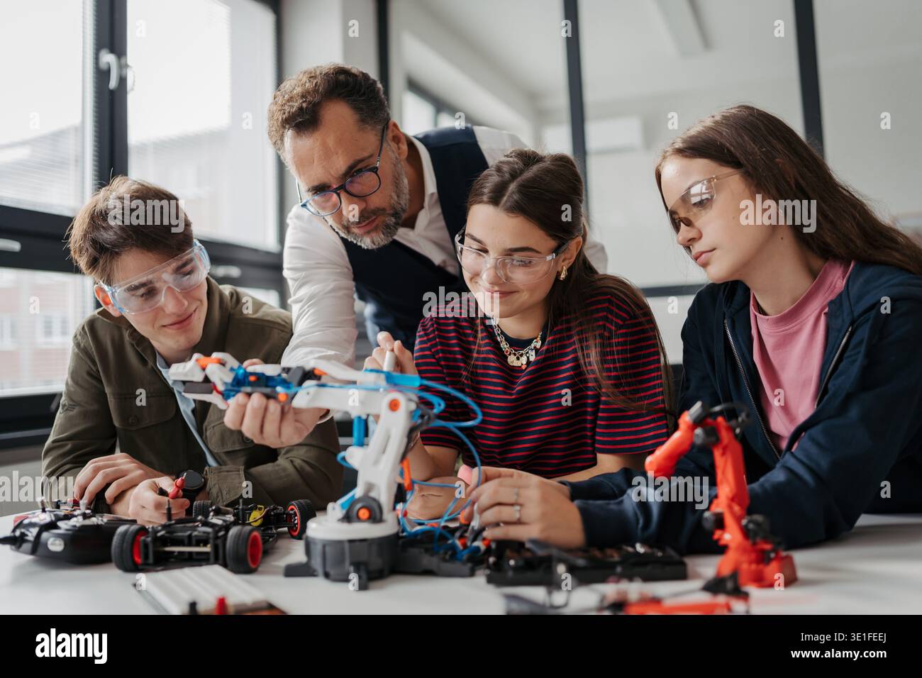 High school students working on robotics project with their teacher. Stock Photo