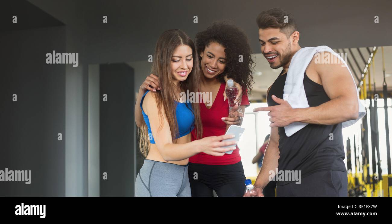 Young friends in sportswear relax after training with smartphone Stock Photo