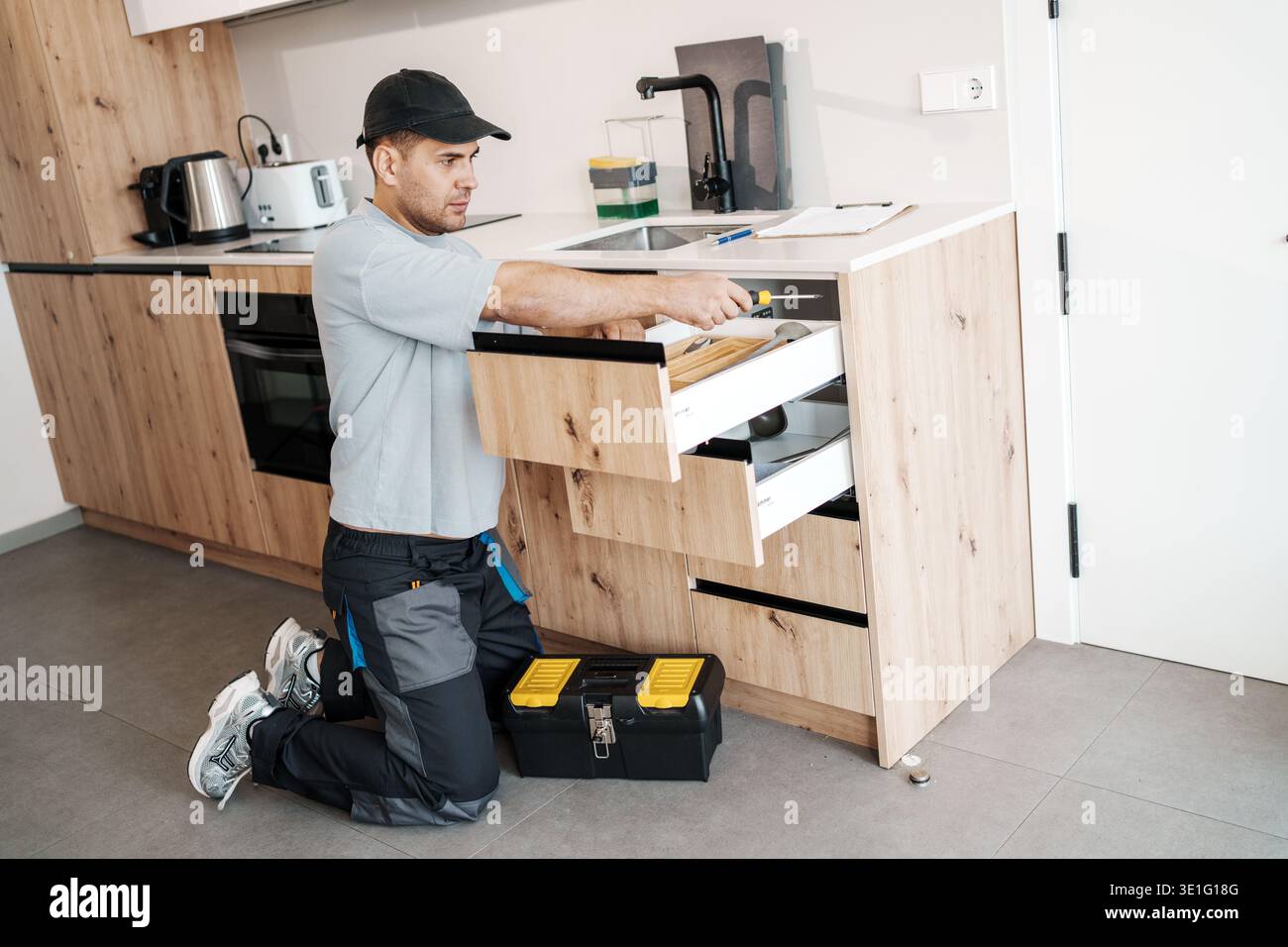 Installer Checks Drawer. Professional Installer Kneels To Examine ...