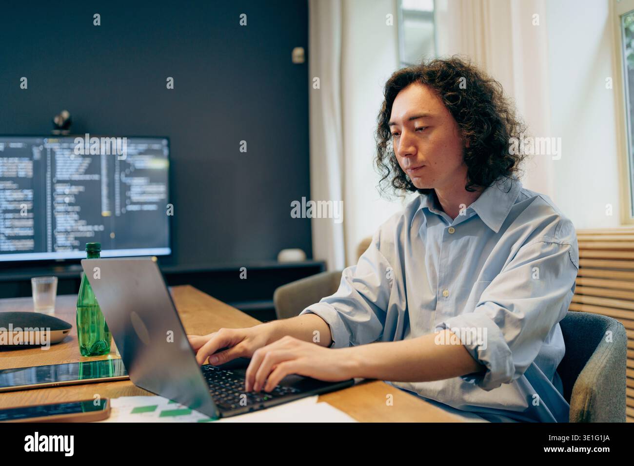 Focused Coder Working, An Attentive Software Engineer Working Diligently In Sleek Office Bathed In Sunlight Stock Photo