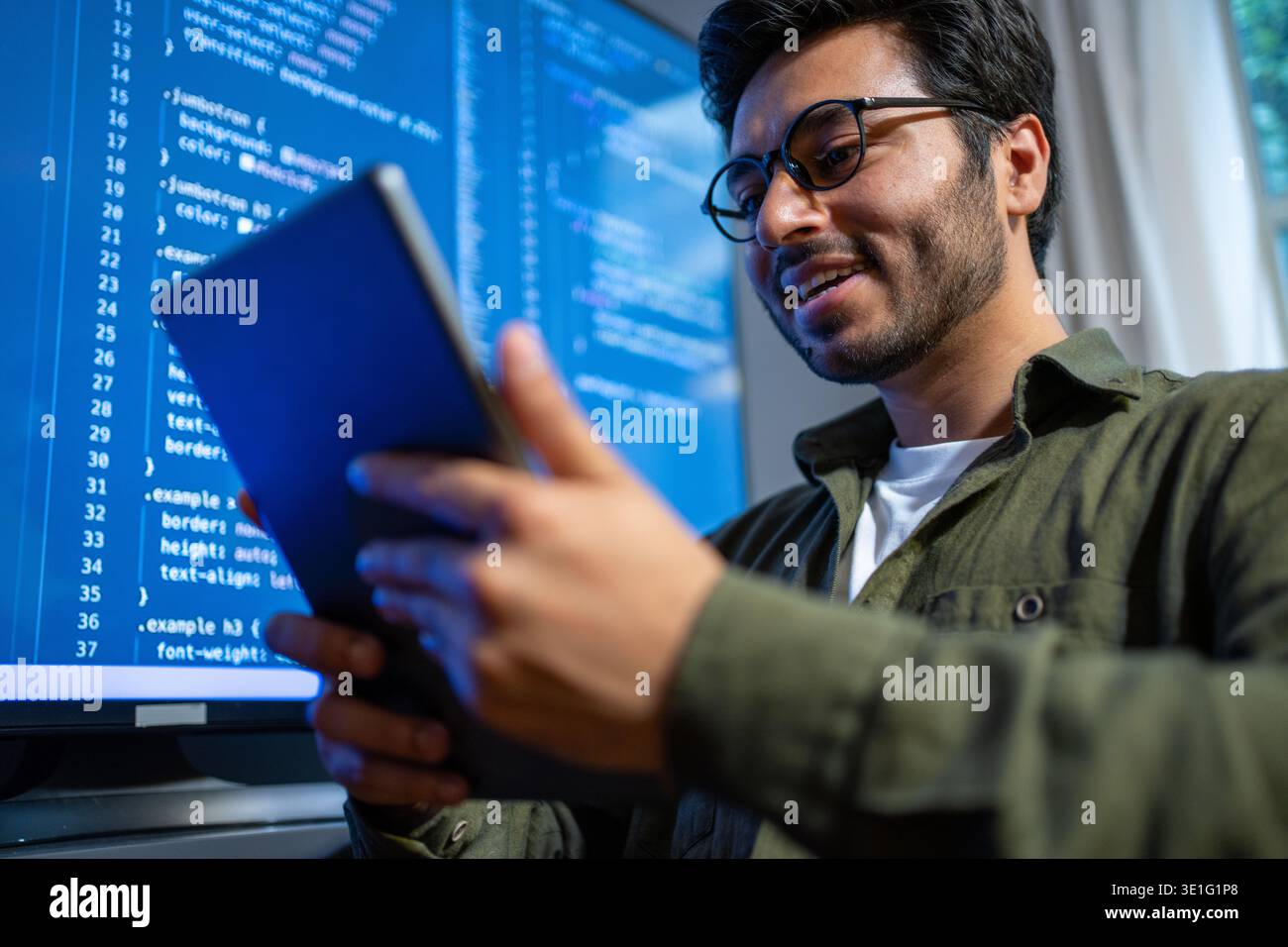 developer evaluates prototype happily today, technician reviews sample on screen with enthusiasm Stock Photo
