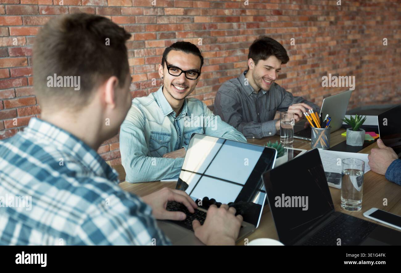 Programmers cooperating at IT company developing apps Stock Photo