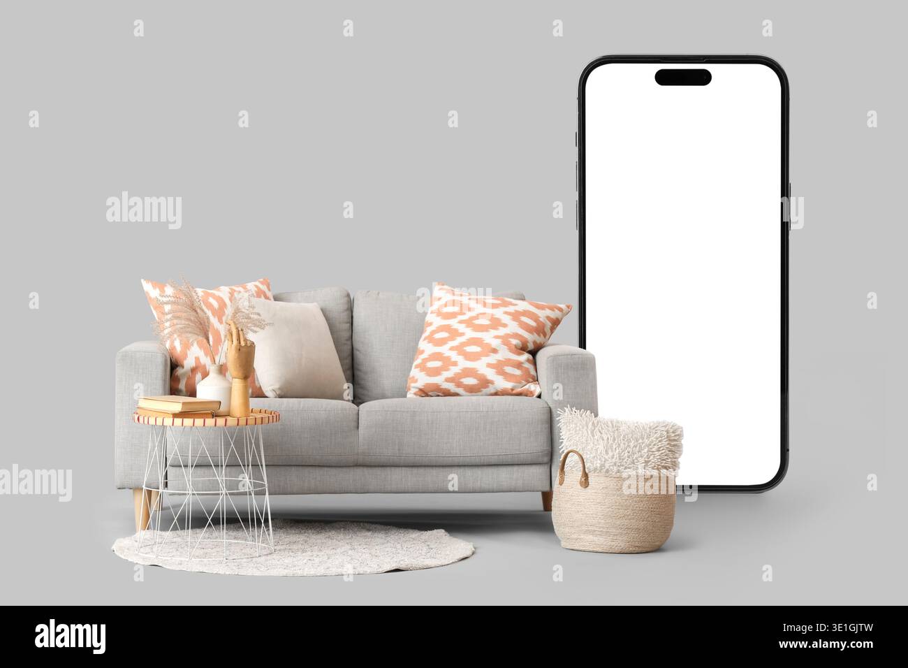 Comfortable sofa and mobile phone with blank screen on grey background Stock Photo
