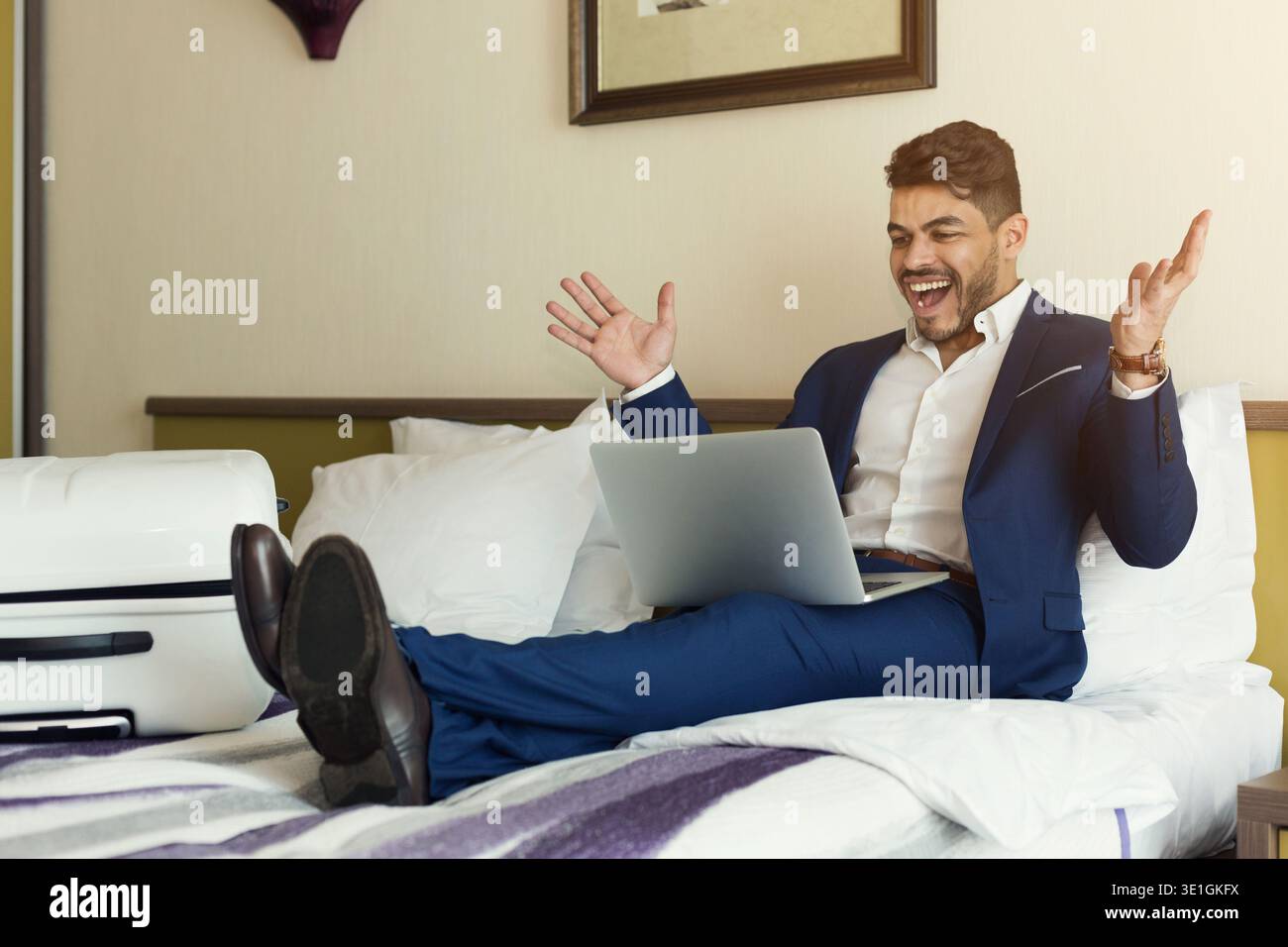 Businessman sitting on bed and using laptop Stock Photo