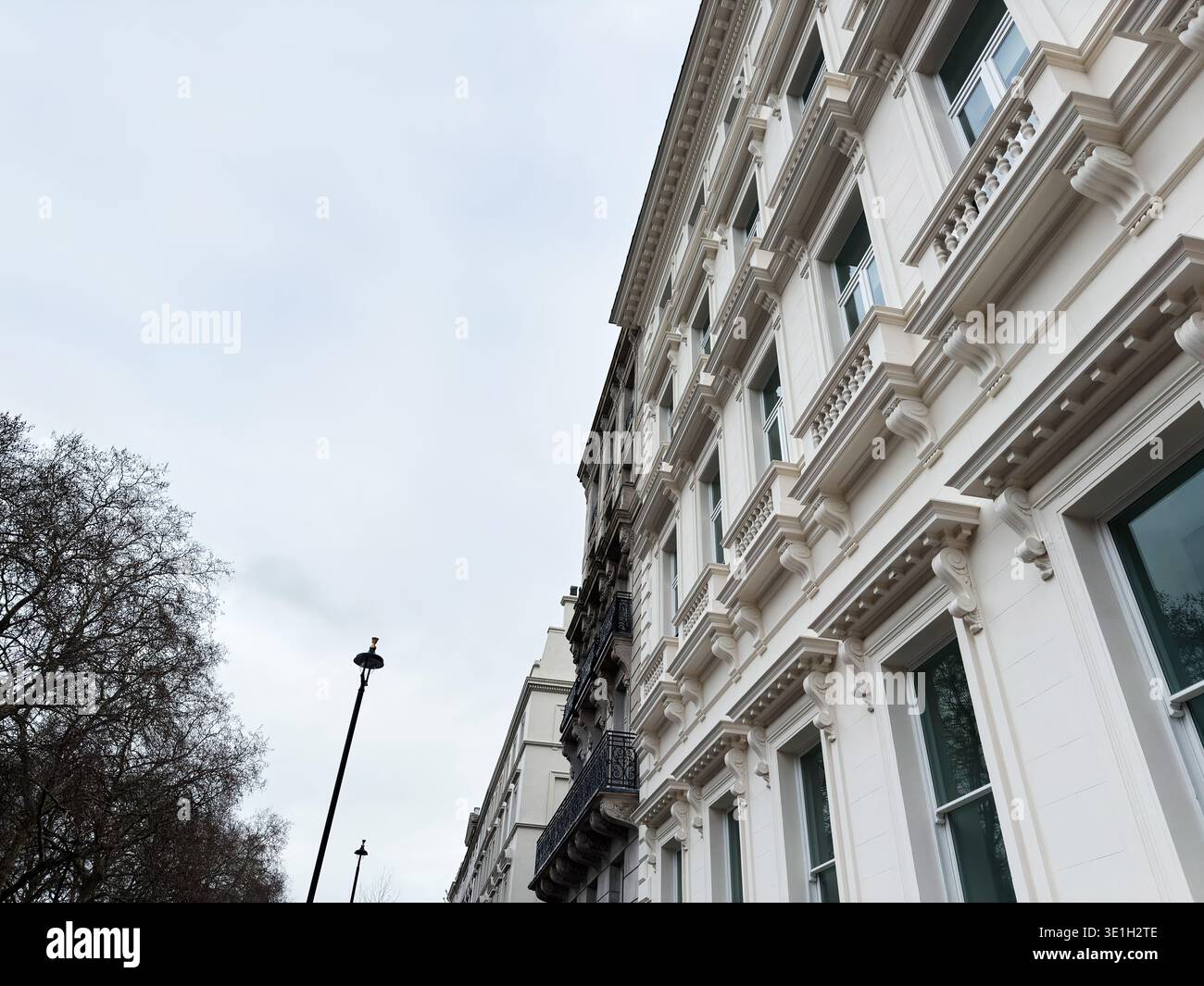 A tall white building with decorative cornices and multiple windows ...