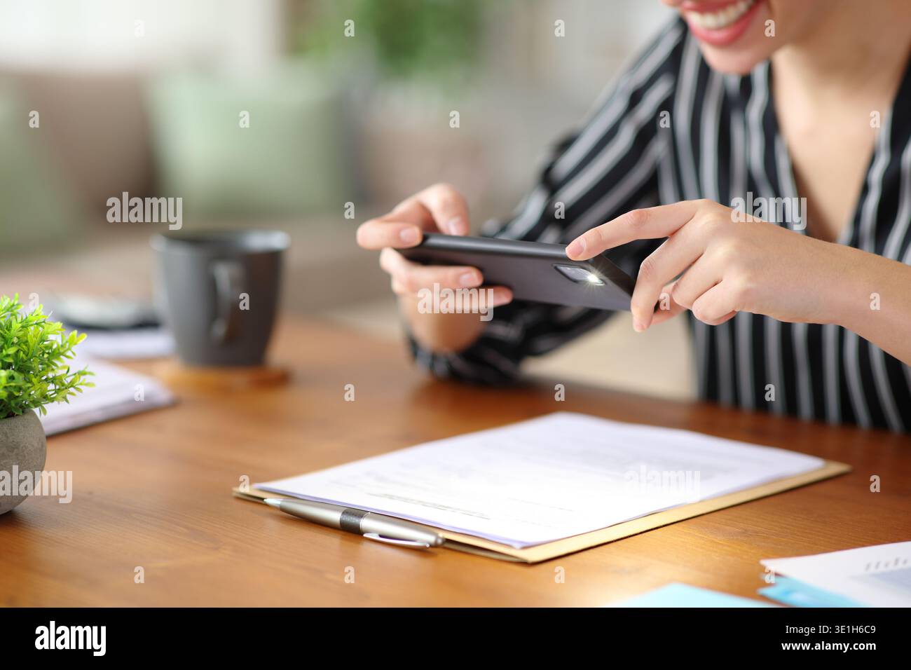 Close up of a happy self employed hands taking photo of paper document working at home Stock Photo