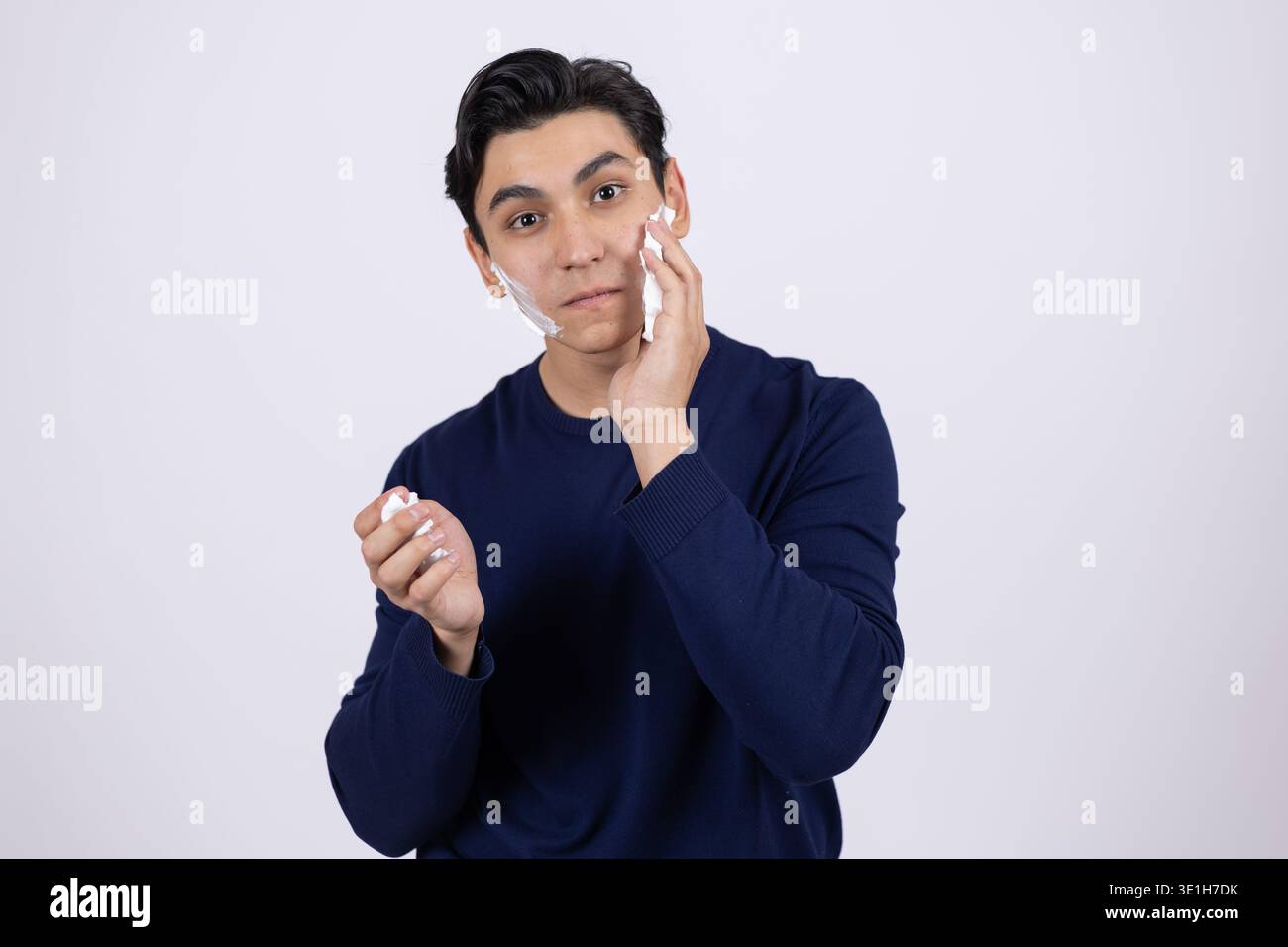 Young man thinking and touching his face with hand Stock Photo