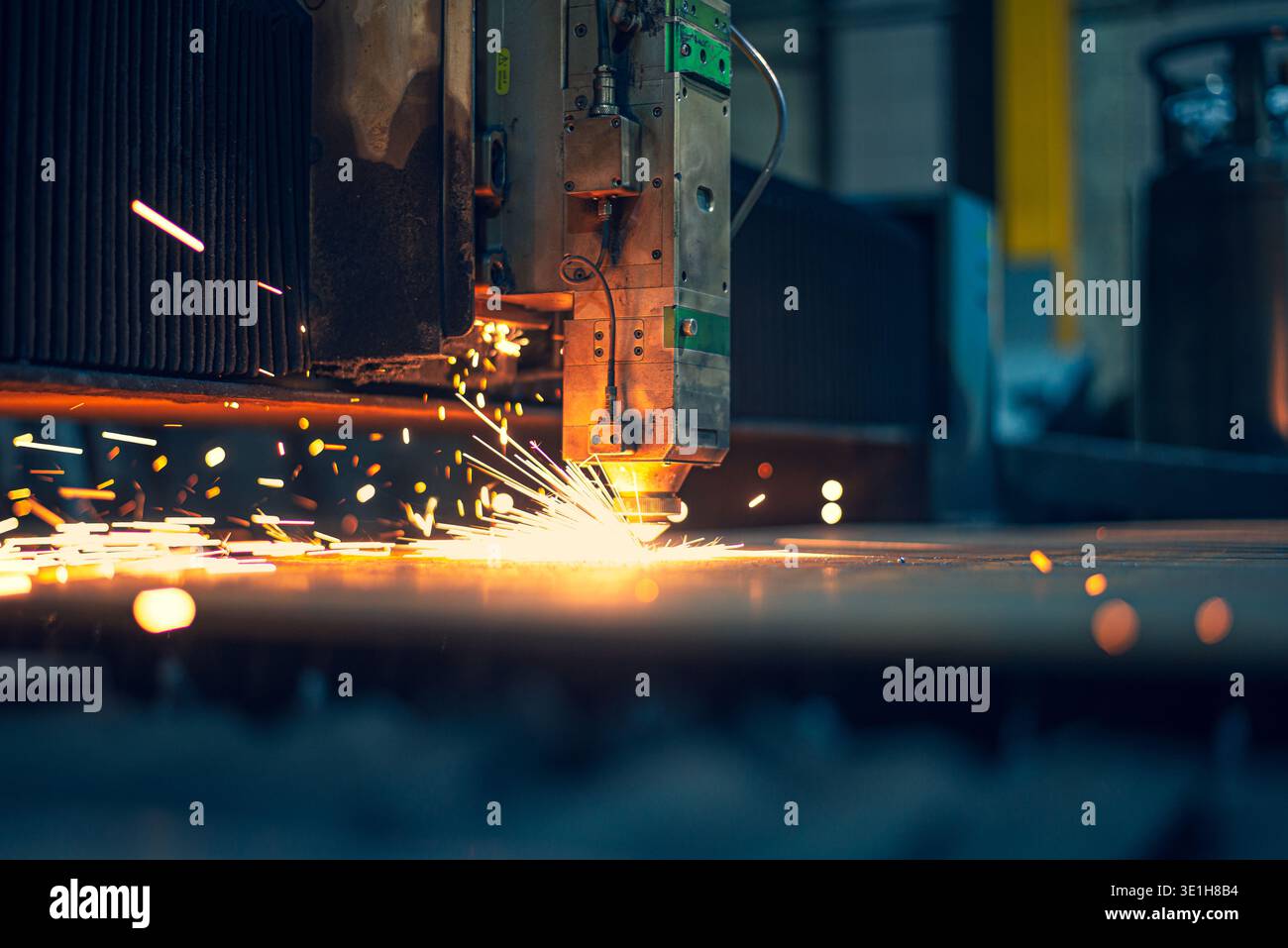 A beautiful bright moment of cutting a sheet of metal with a laser releasing sparks. Automatic Programmed Laser Metal Cutting Machine. High quality ph Stock Photo