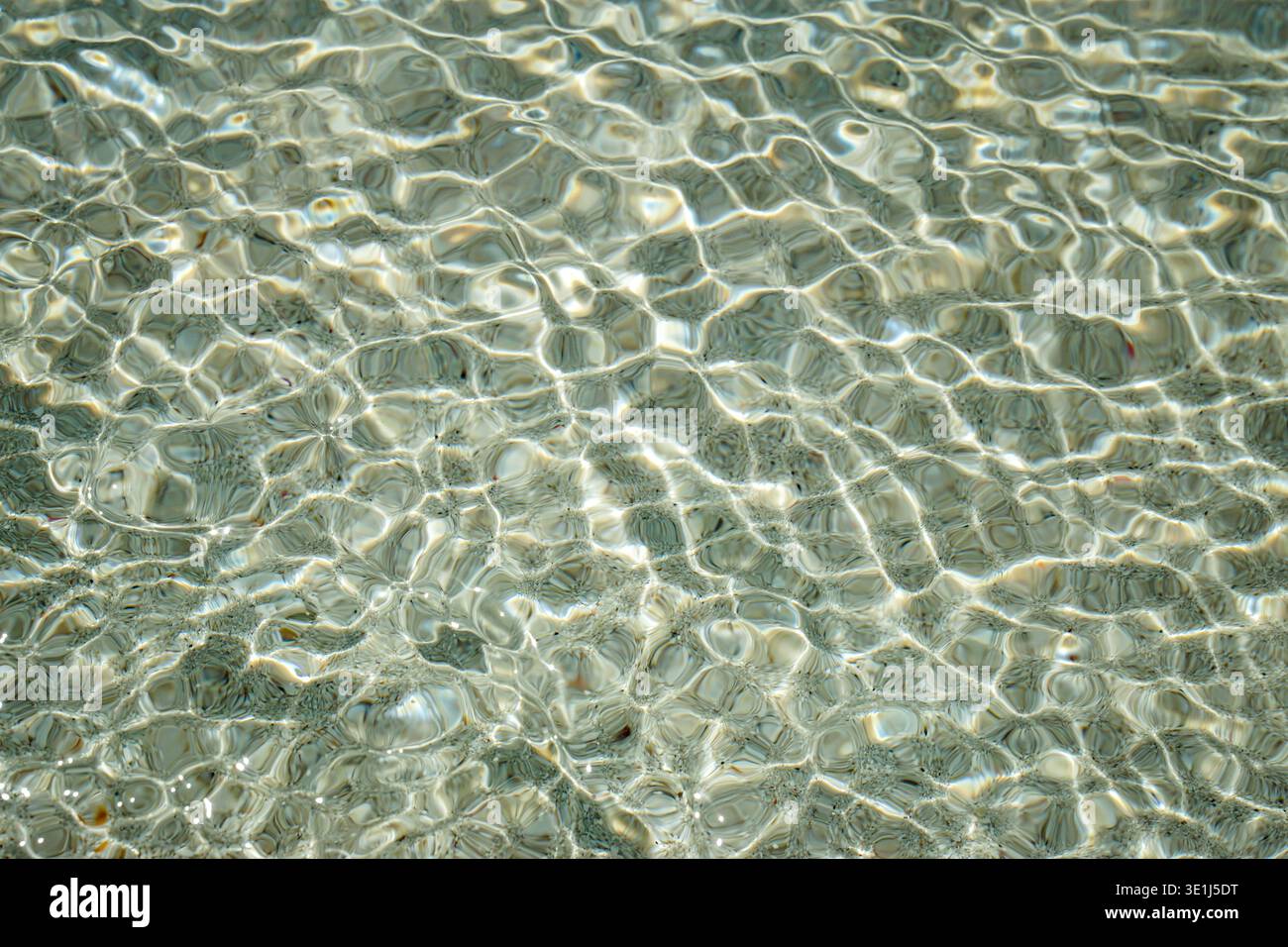 Sandy Ripple Clear shallow seawater with sunlight reflections creating ripple ...