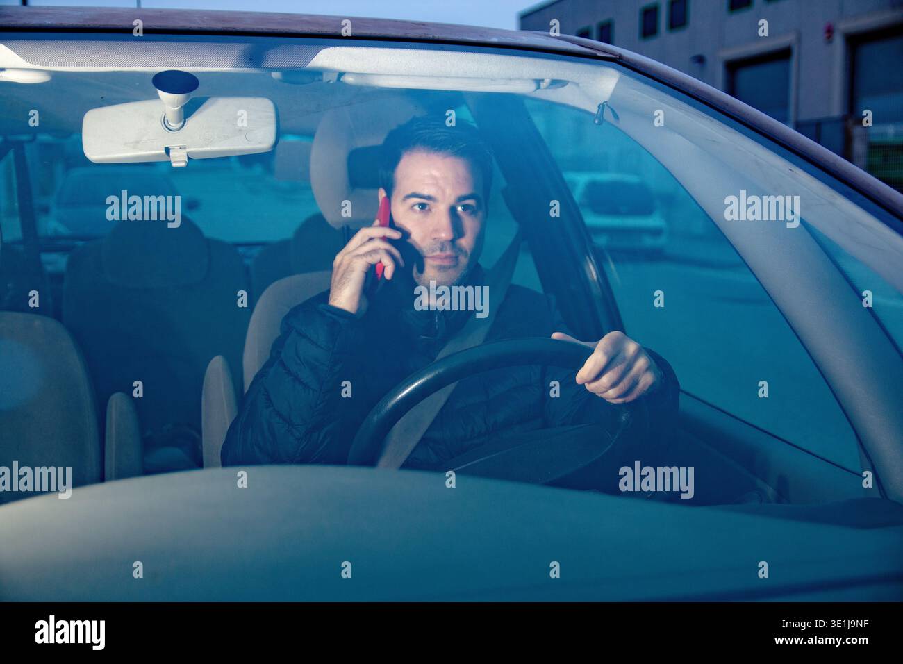 Driver distracted using mobile phone while driving car Stock Photo