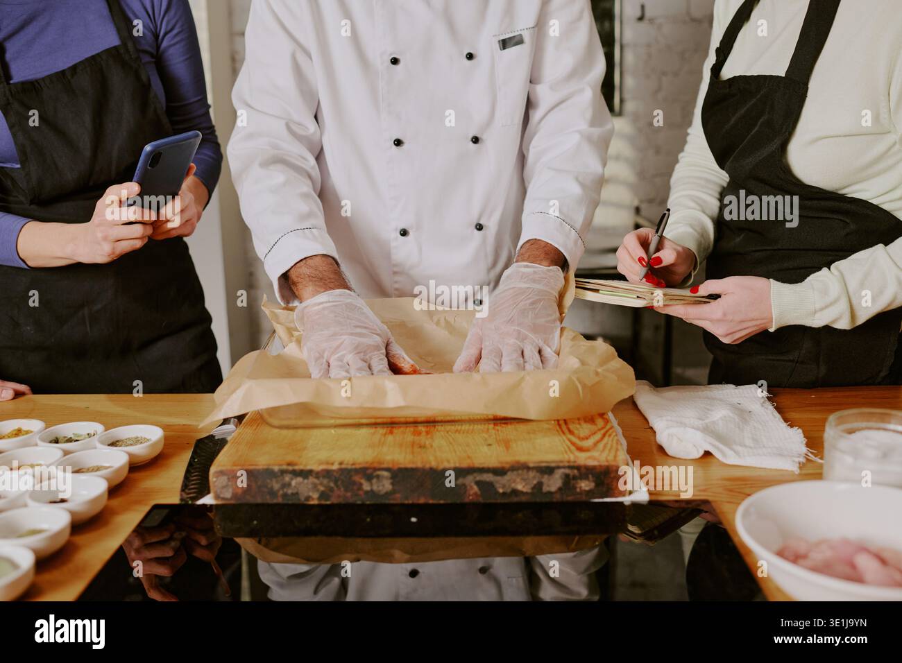 Middle Aged Man Teaching Cooking Class with Students Observing Stock Photo