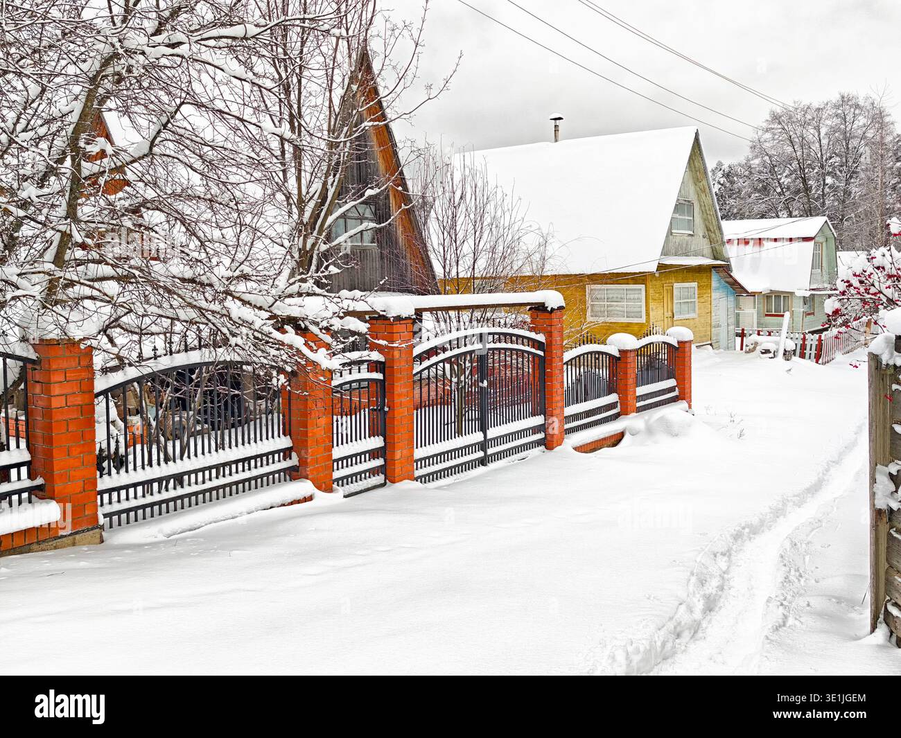 Traditional wooden houses line a snowy street in a rural village in ...