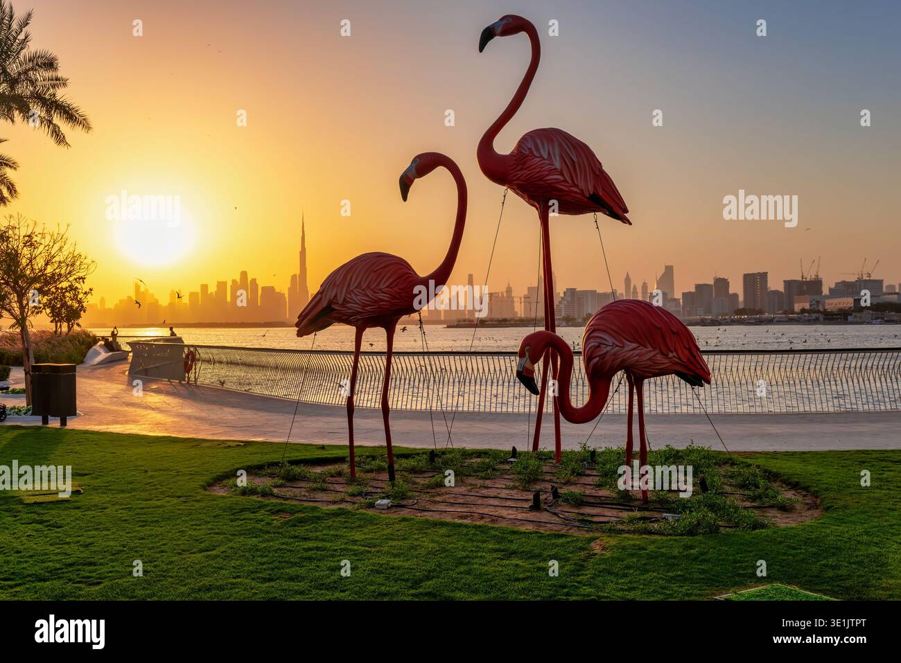 Sunset view from Dubai Creek Harbour towards the skyline with the famous flamingo statue in front Stock Photo
