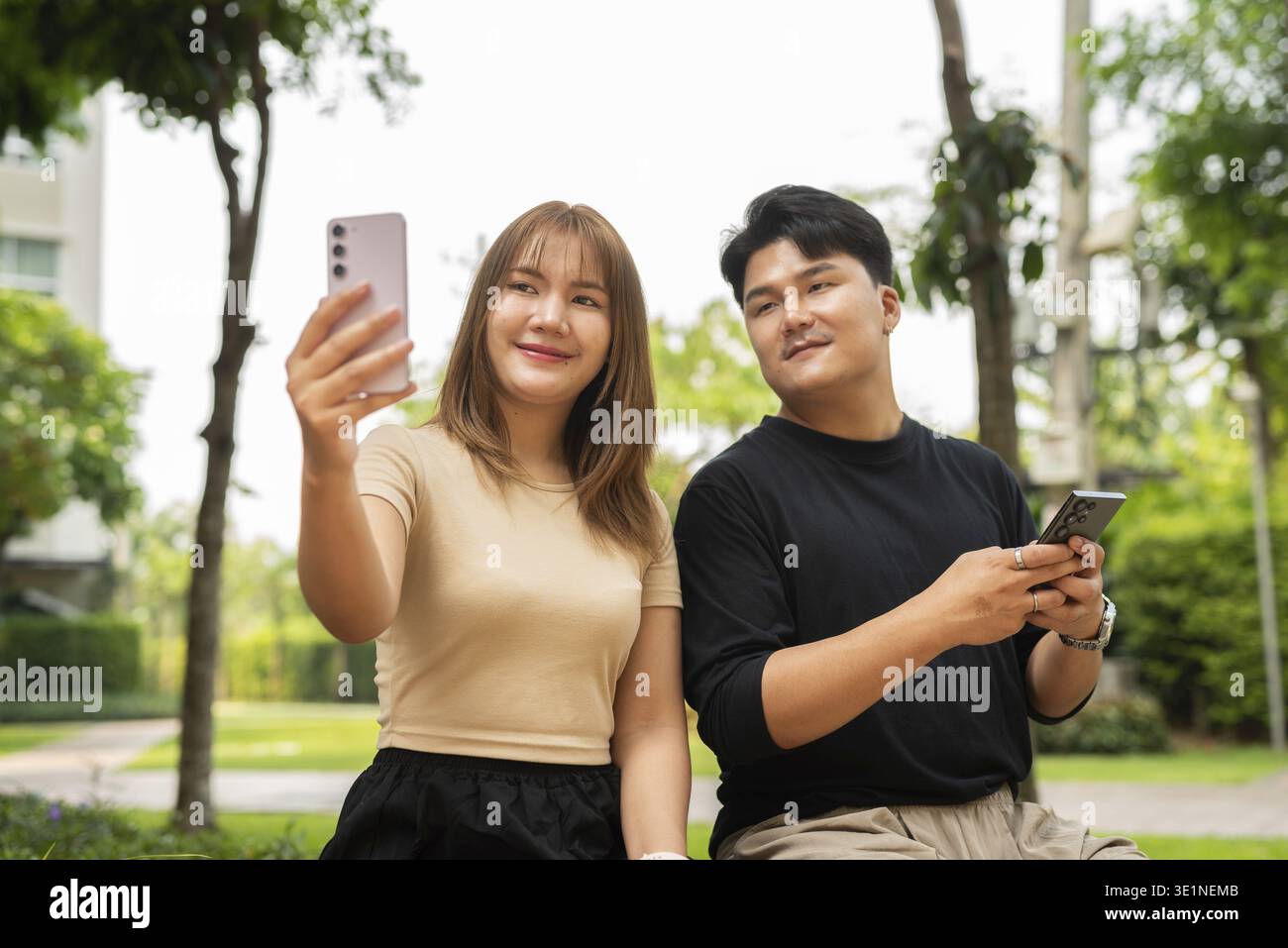 Young happy Asian couple outdoors in park Stock Photo