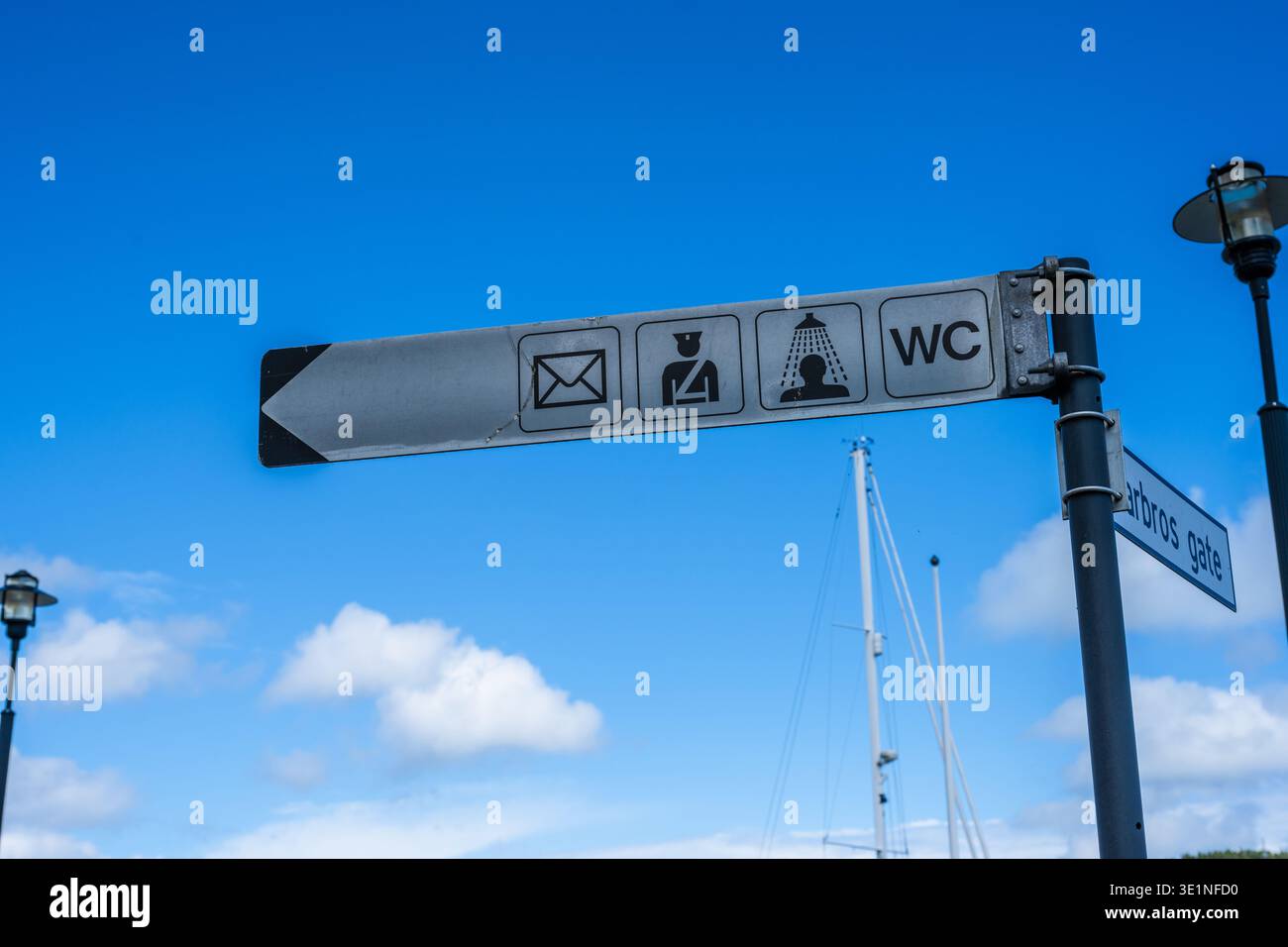 Farsund, Norway - July 02 2023: Sign pointing the way to different services such as post office police station showers and toilet Stock Photo