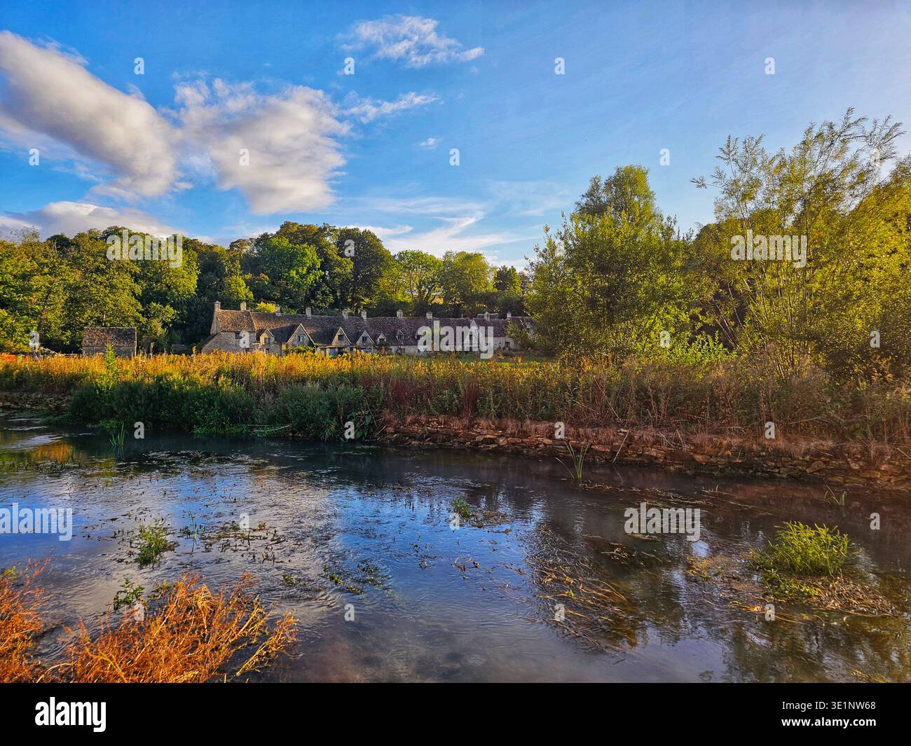 A picturesque summer scene of Arlington Row in Bibury, one of England's most iconic Cotswold villages - Smartphone Captured Stock Image