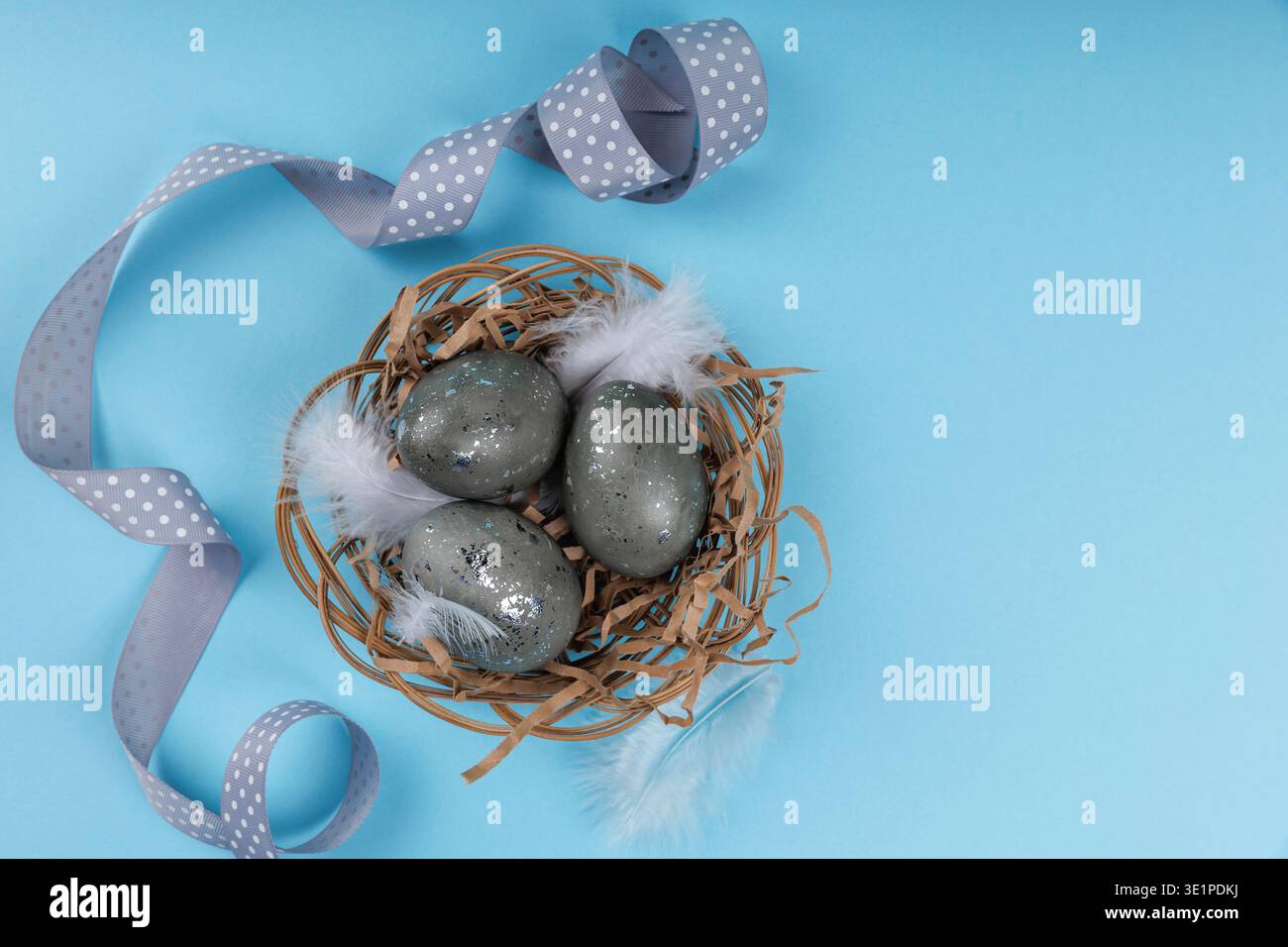 Decorative Easter eggs with silver speckles in nest Stock Photo