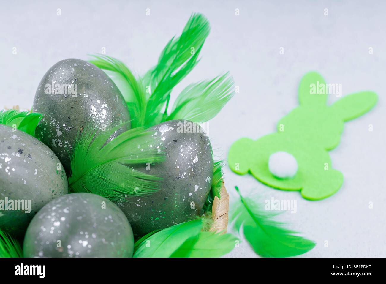 Decorative easter eggs with green feathers and bunny symbol Stock Photo