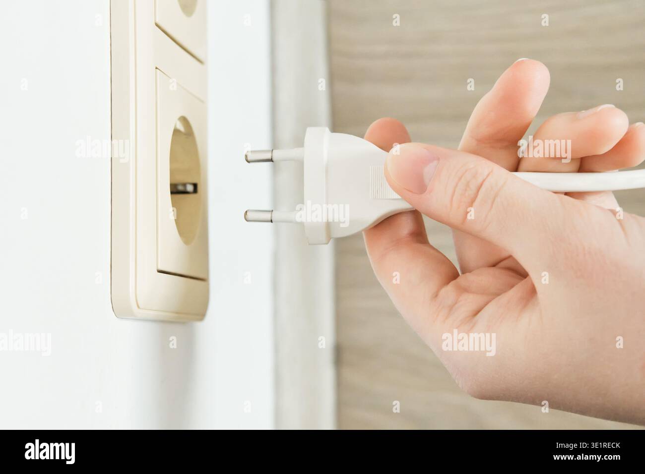 Hand holding electrical plug ready for power connection Stock Photo