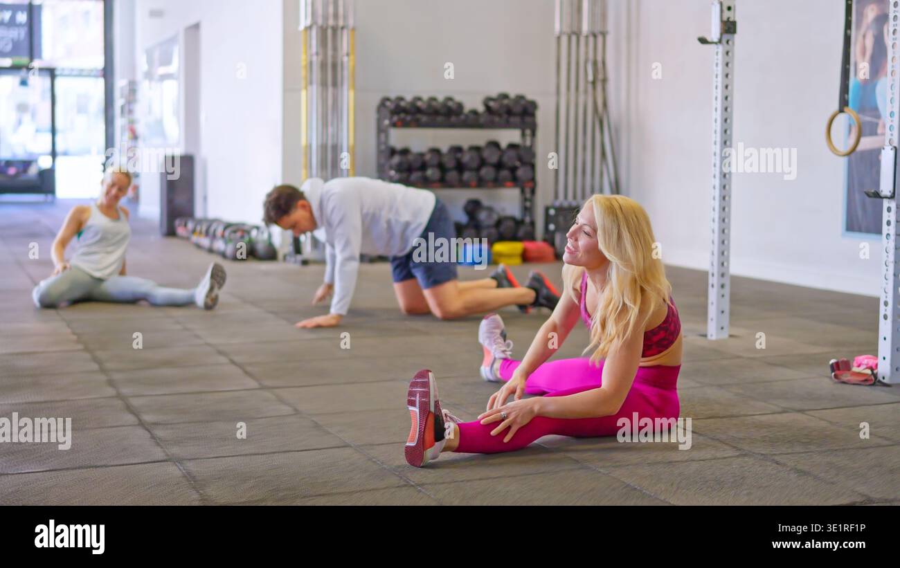 Active people doing stretching exercises for flexibility in gym Stock Photo