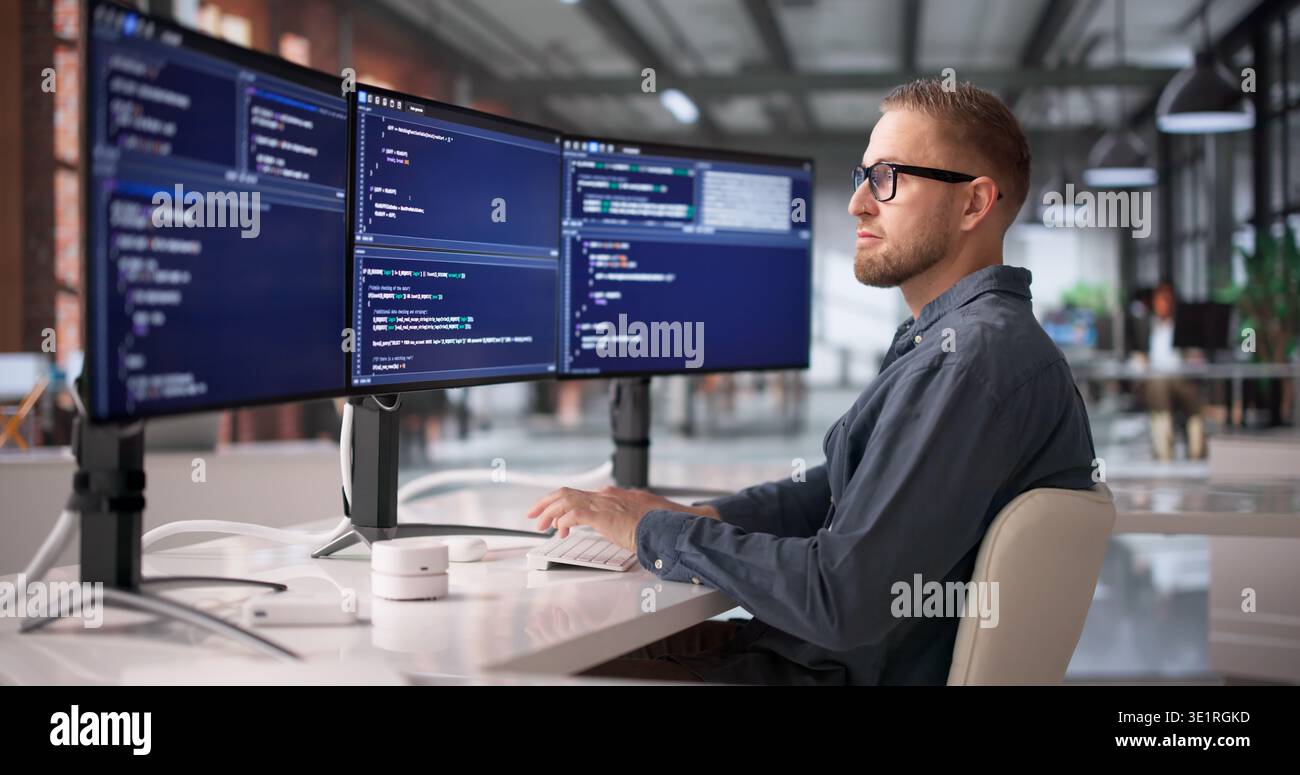 Software Engineer Concentrating On Programming And Debugging At Workstation Stock Photo