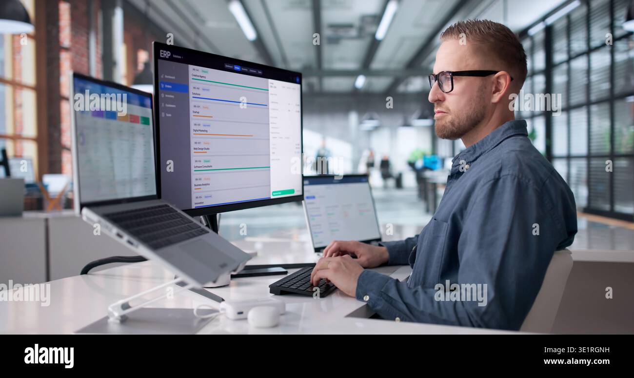 Young Professional Managing Cloud-Based ERP Software On Laptop For Business Optimization Stock Photo