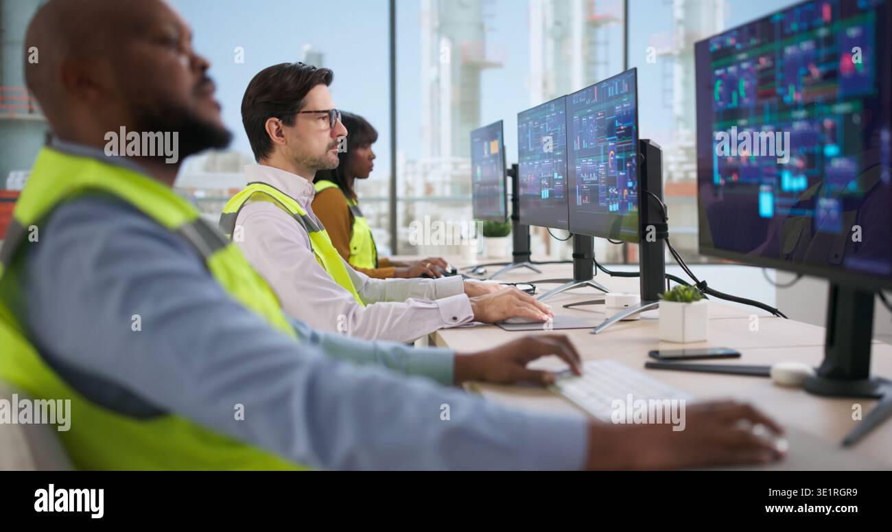Young Engineer Operates Industrial Automation System On Computer, Ensuring Safety. Technician Monitors Data Processing Stock Photo