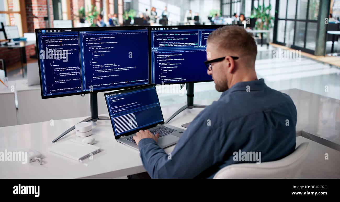 Dedicated Programmer Developing Innovative Software At Workstation Stock Photo