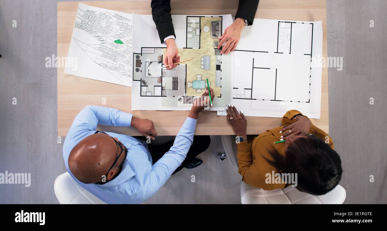 Real Estate Consultant And Interior Designer Discussing Apartment Remodel Plans. An Engineer Stock Photo