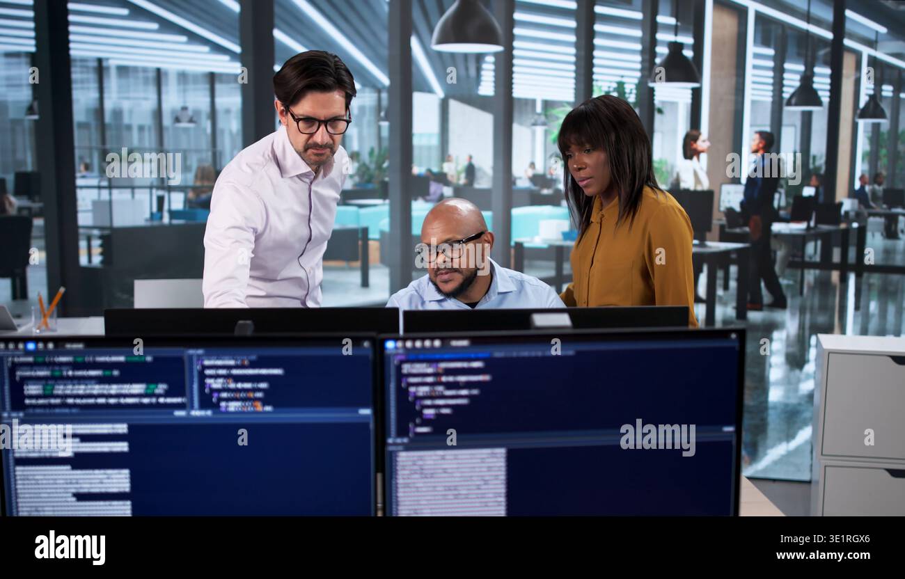 Diverse Team Of Developers Coding Software Projects On Desktop Computers In Office Stock Photo