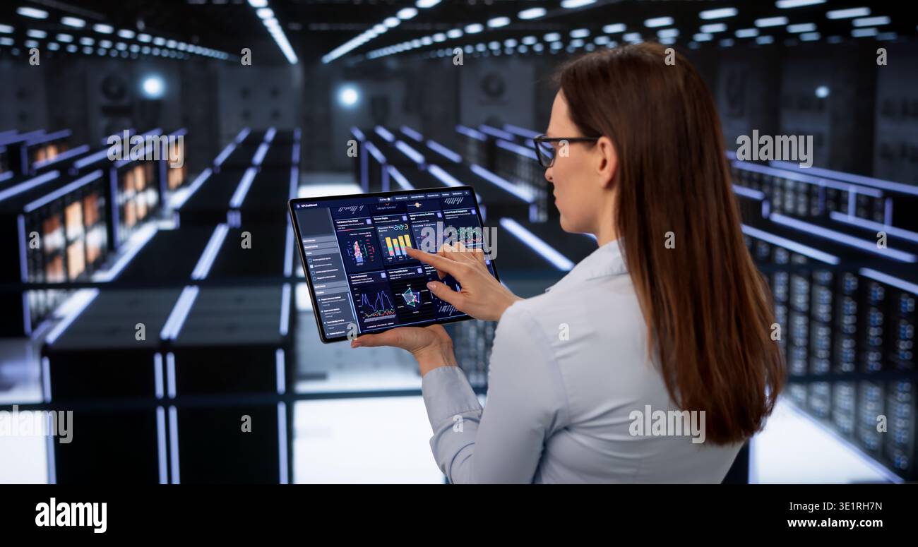 Female Data Specialist Monitors Cloud Servers For Security In High-Tech Facility Stock Photo