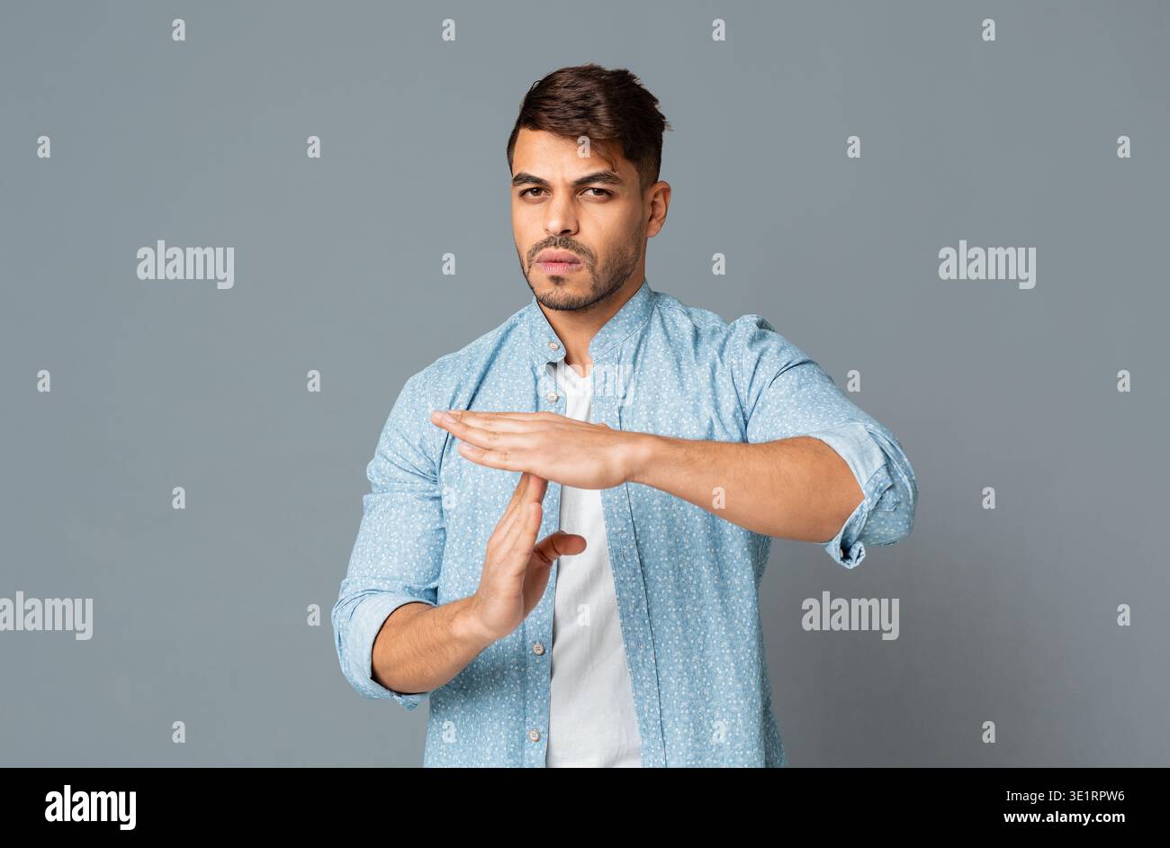 Man Making Time Out Gesture On Gray Background Stock Photo
