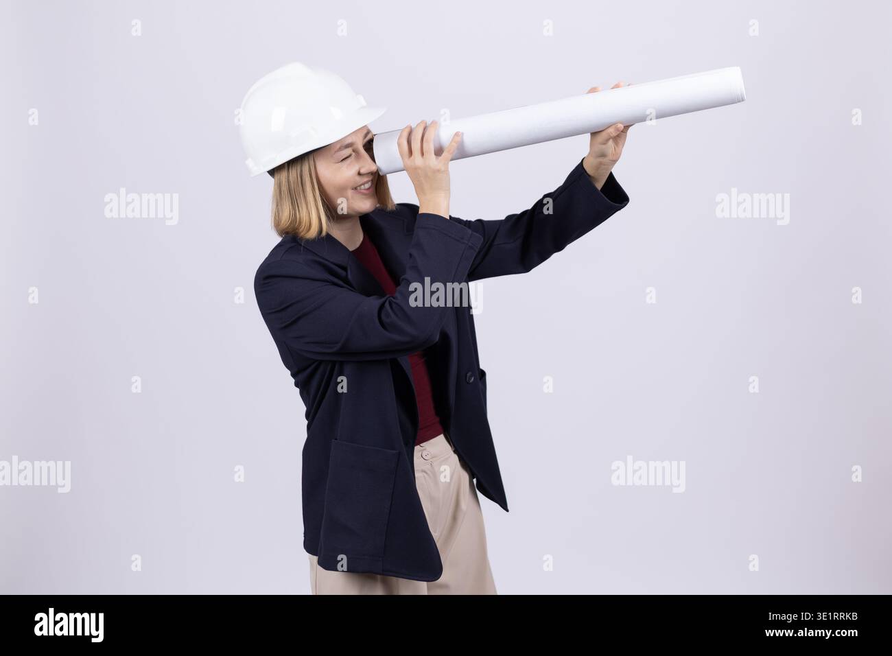 Female architect looking through rolled blueprint Stock Photo