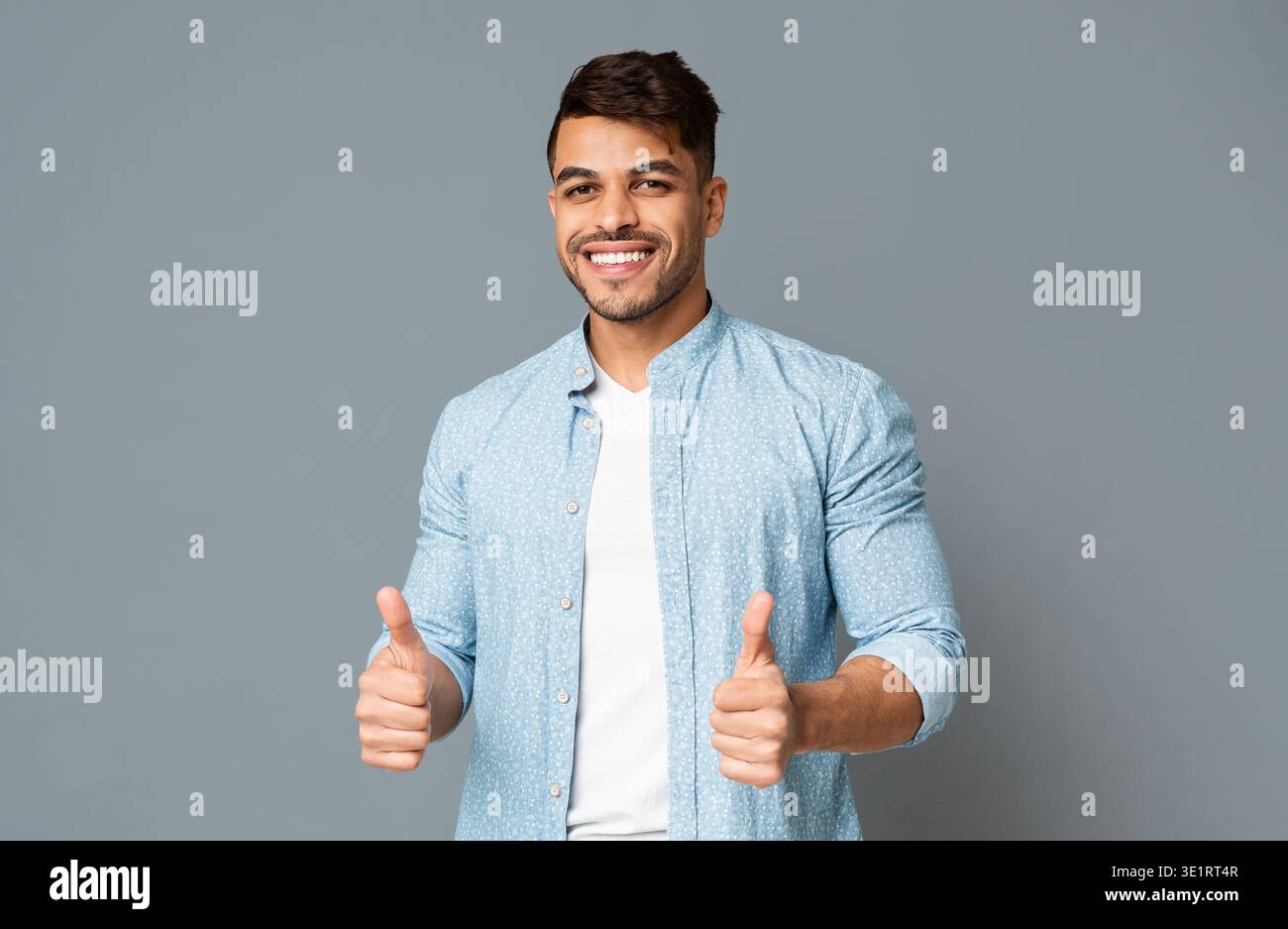 Smiling Guy Showing Thumbs Up With Both Hands Stock Photo