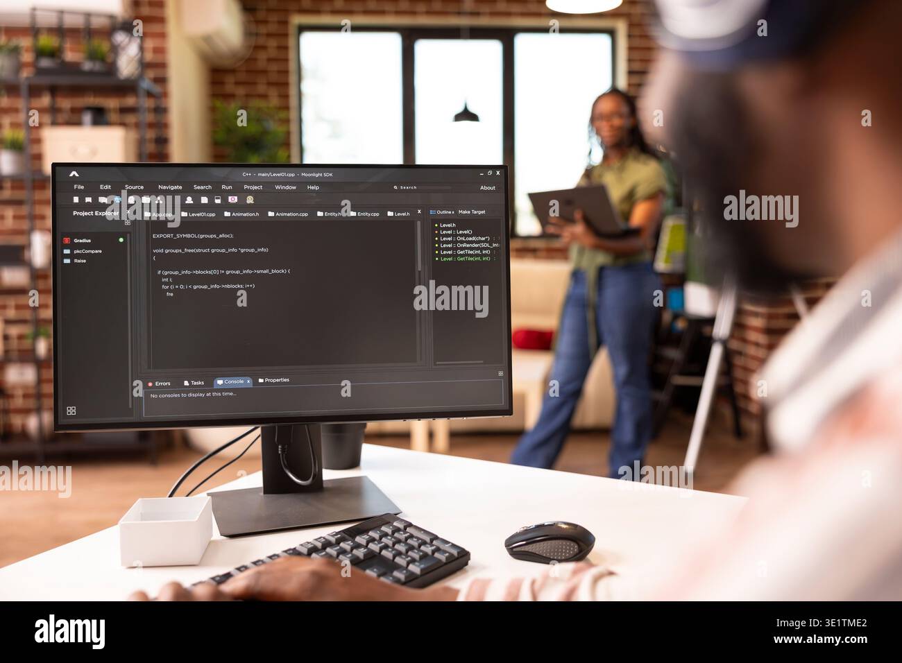 African american software developer typing at home desk, refining code and solving bugs on computer. Male remote worker focuses on improving application performance in home workstation. Stock Photo