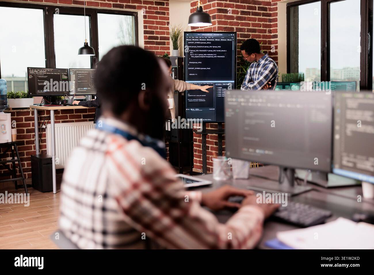 Diverse system engineers working on it project for the company network technology, utilizing their expertise in coding systems. Software developer programming big data in agency office. Stock Photo