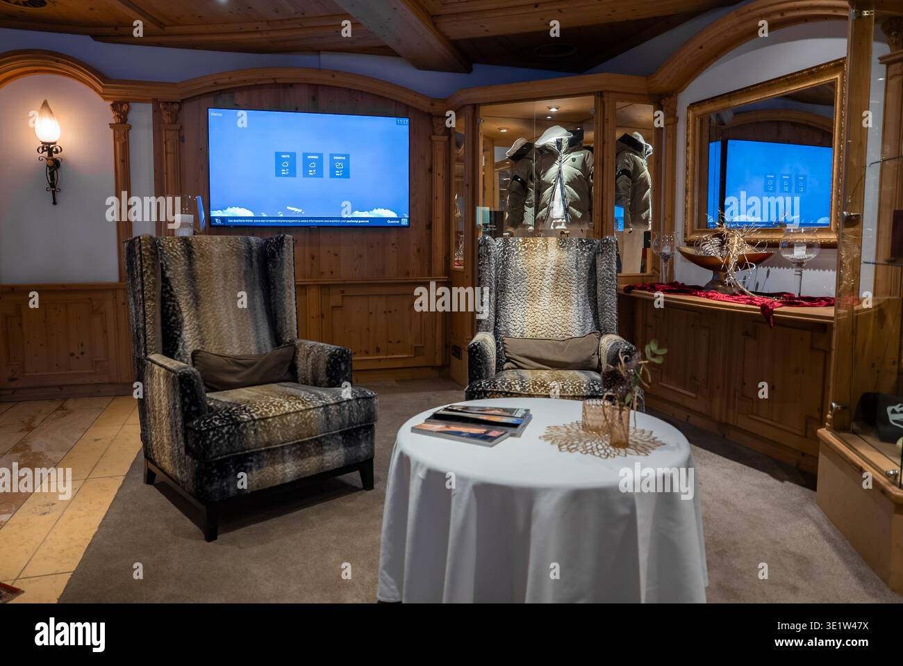 Alpine hotel lounge with wing chairs, wood paneling, and TVs Stock ...