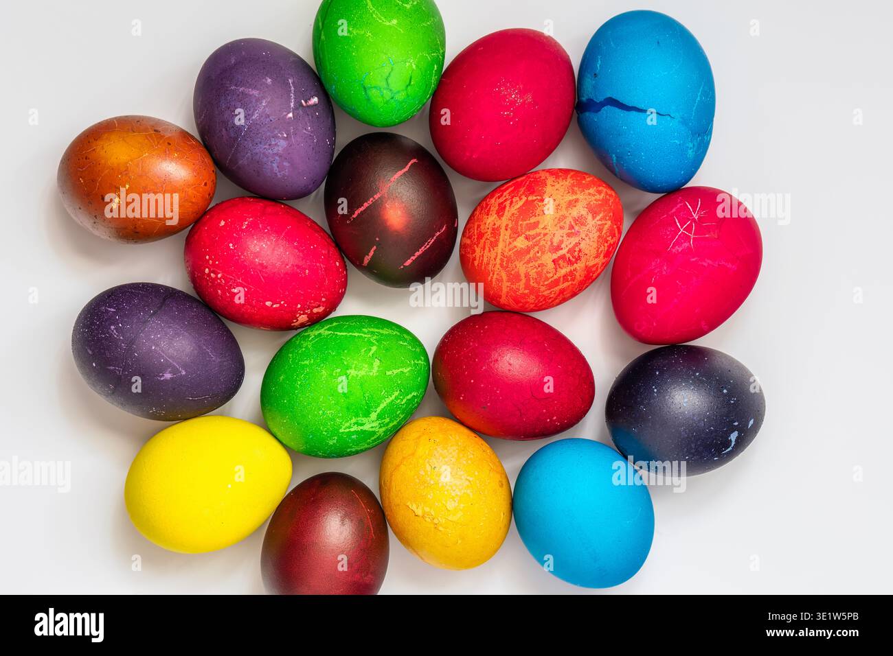 Easter eggs painted in different colors, custom patterns on a white background, top view Stock Photo