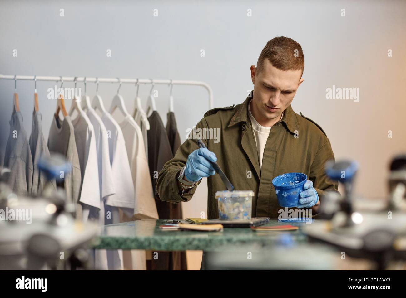 Young Adult Man Mixing Paint While Working in Creative Studio Stock Photo
