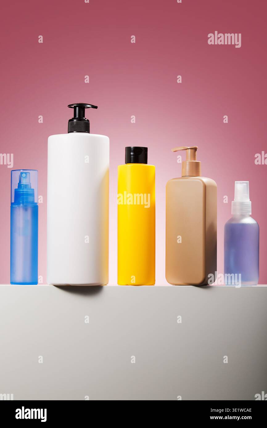 Assorted skincare bottles on pink studio background Stock Photo