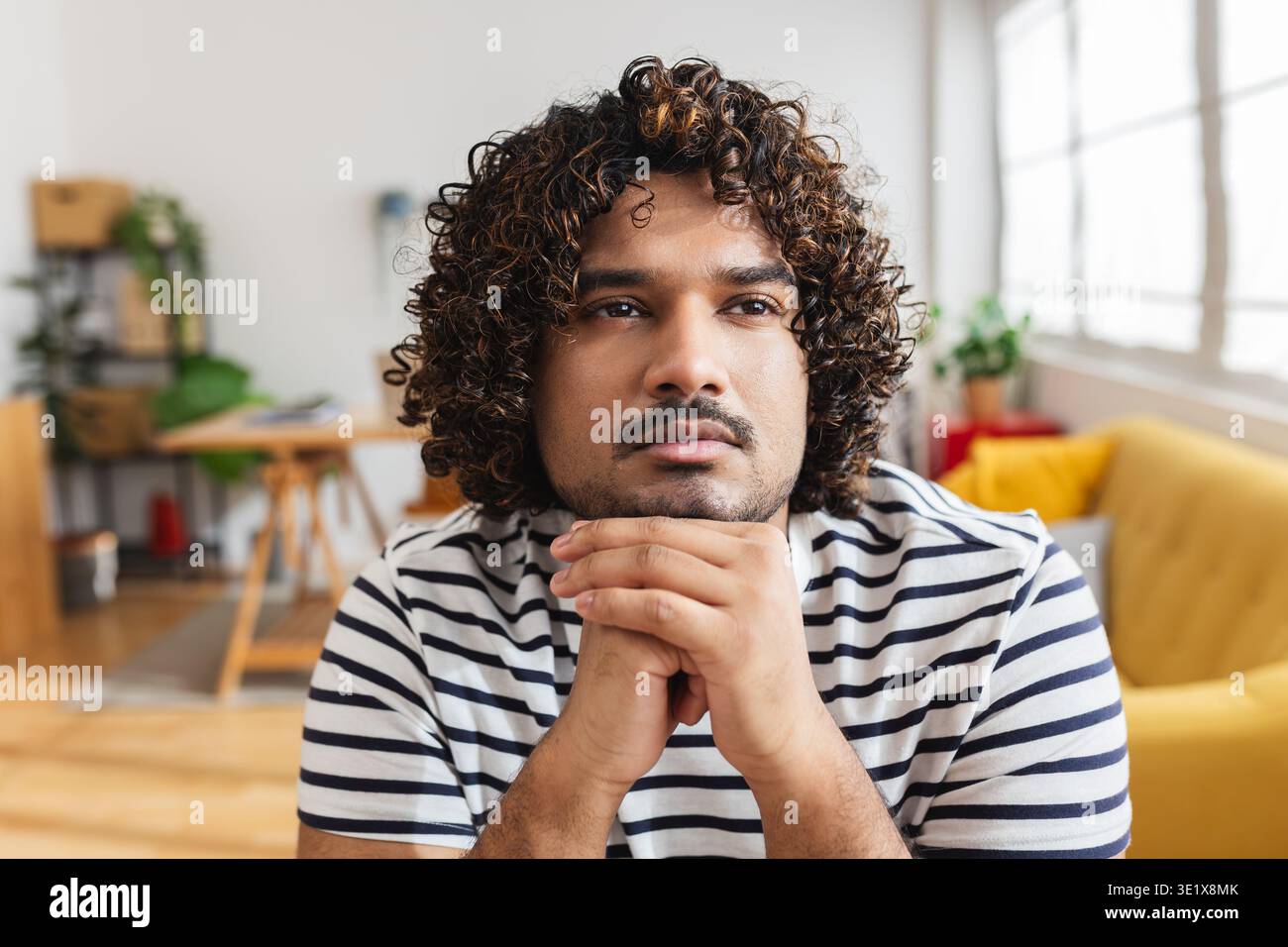 Young Indian man thinking at desk workplace Stock Photo