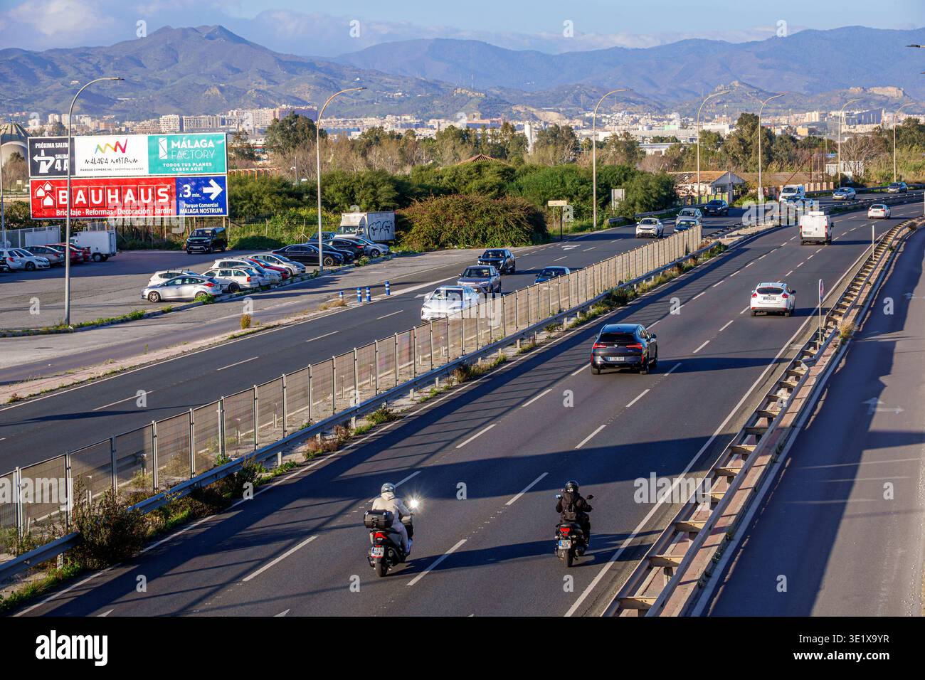 Malaga Spain,Andalusia Andalucia,MA21 highway multilane roadway traffic cars motorcycles urban transportation infrastructure city outskirts mountains Stock Photo