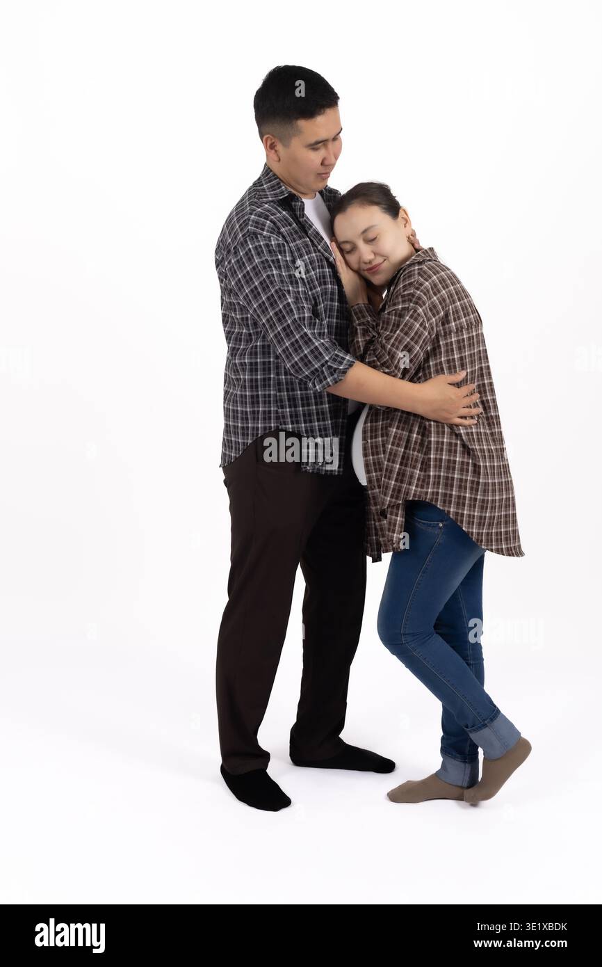 Young couple in checkered shirts hugging on white background Stock Photo