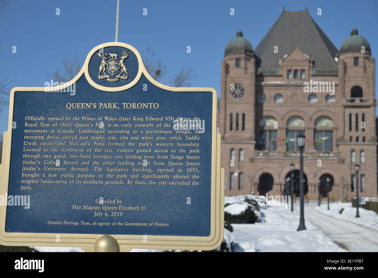 Ontario Heritage Trust plaque with inscription for Queen's Park, Toronto, and defocused view of Ontario Legislative Building, Toronto Stock Photo
