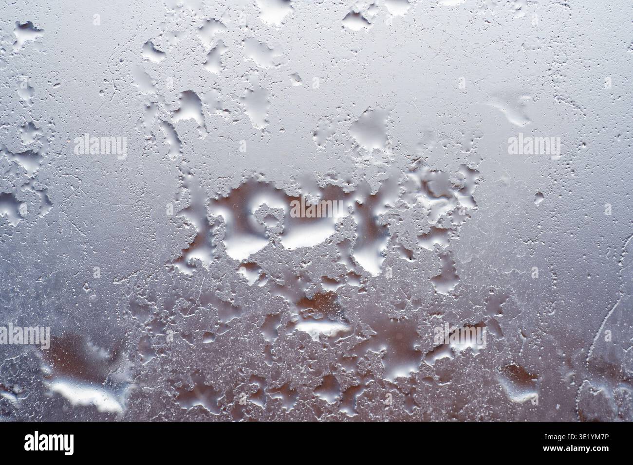 Close up of water droplets on glass surface with blurred background. Stock Photo