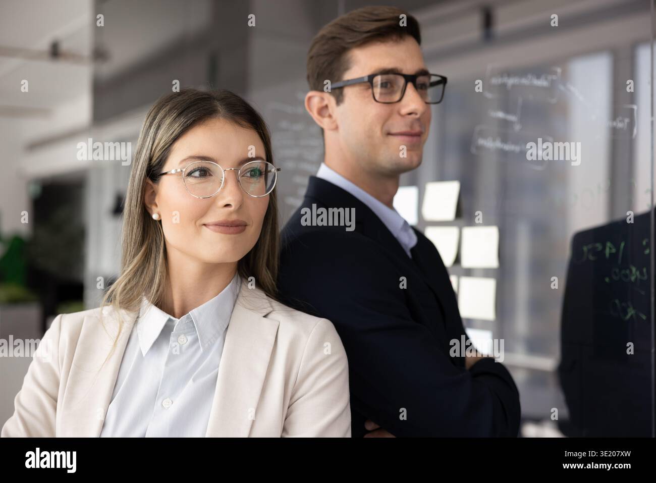Hispanic professionals dressed in formal wear posing together in office Stock Photo